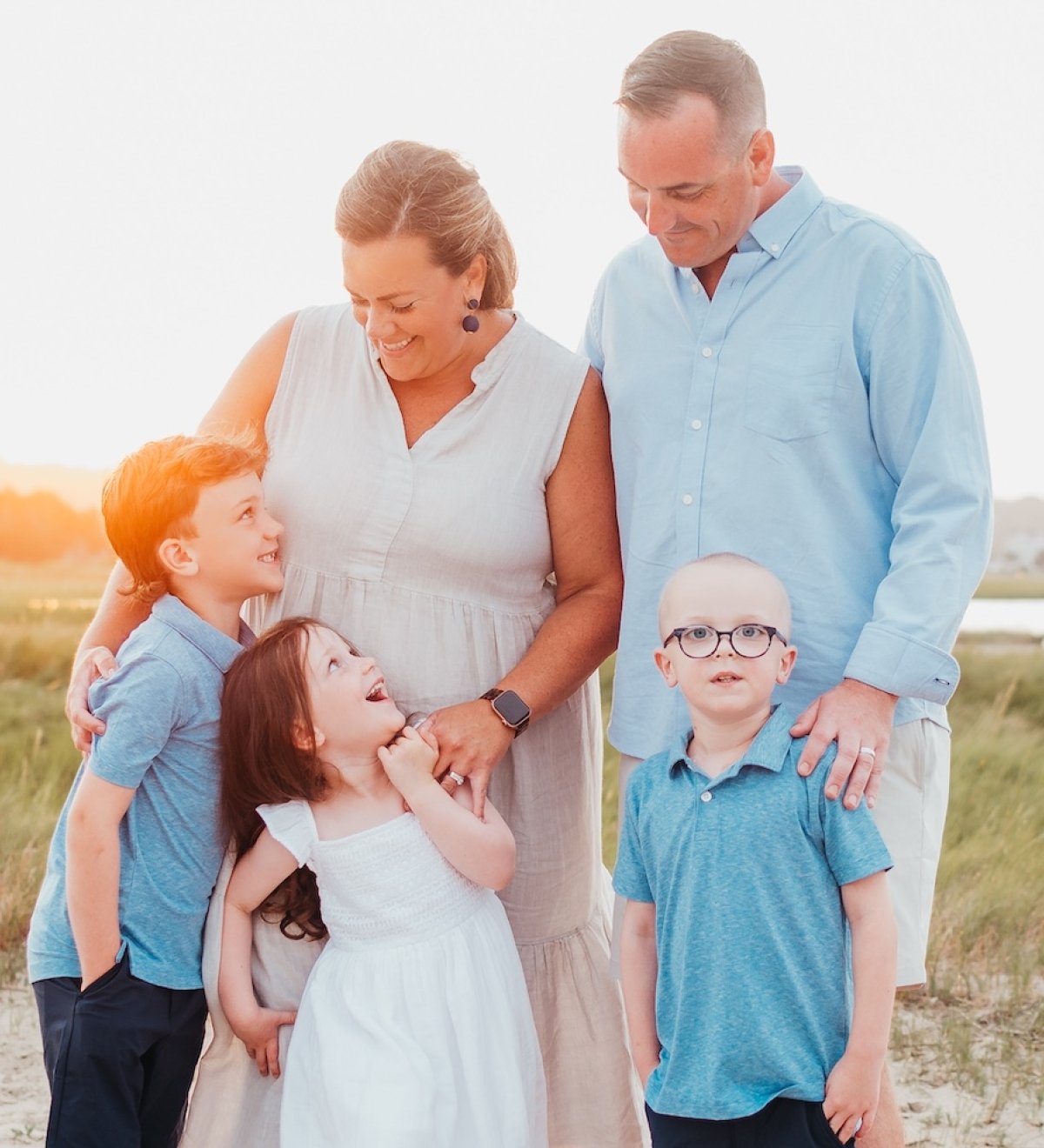 A family of five at the beach during sundown