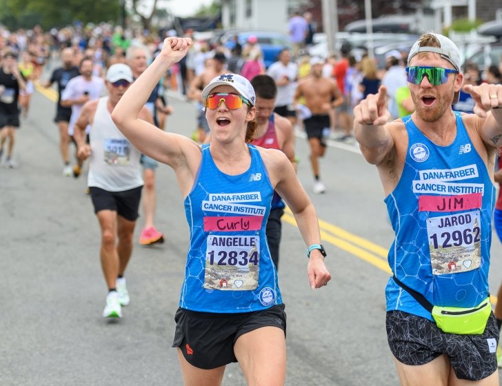 Two runners cheering on the course at the Falmouth Road Race