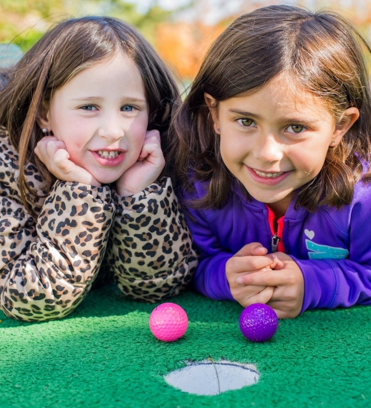 Two young children at a mini golf hole