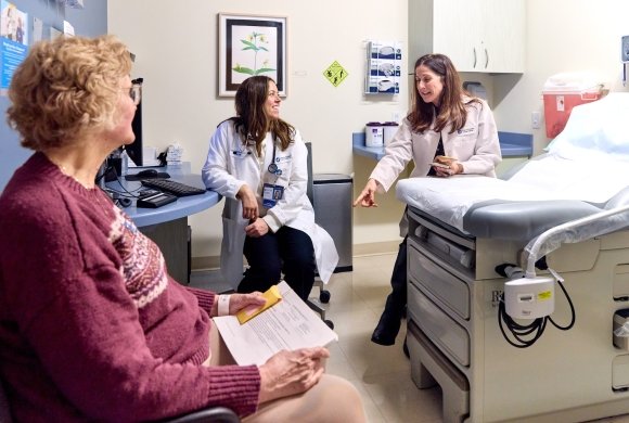 A patient and two caregivers in an exam room