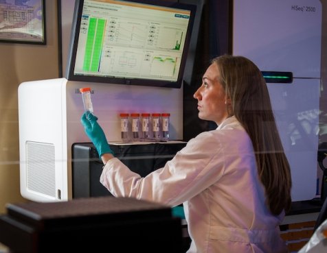 A lab technician analyzing data at a sequencing machine