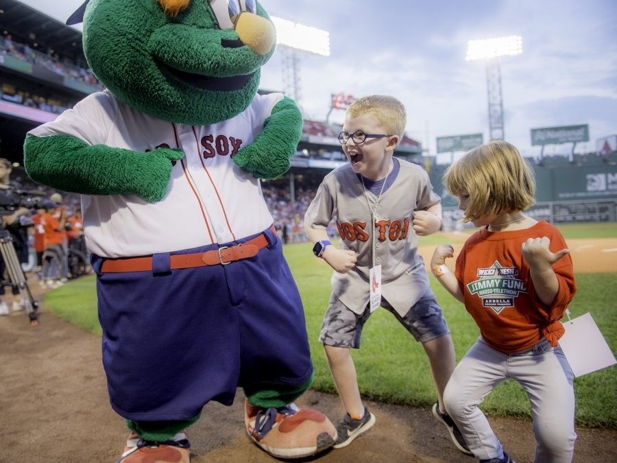 Two kids dancing with Red Sox mascot Wally at Fenway Park