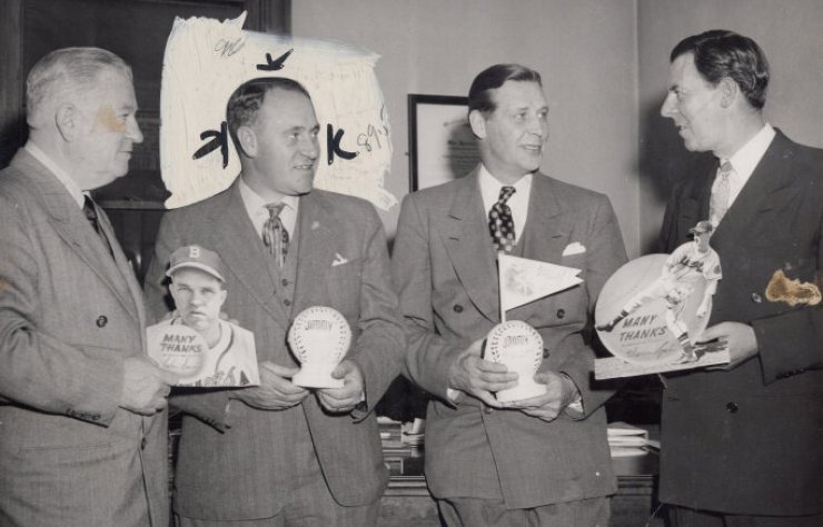 Four people hold baseballs