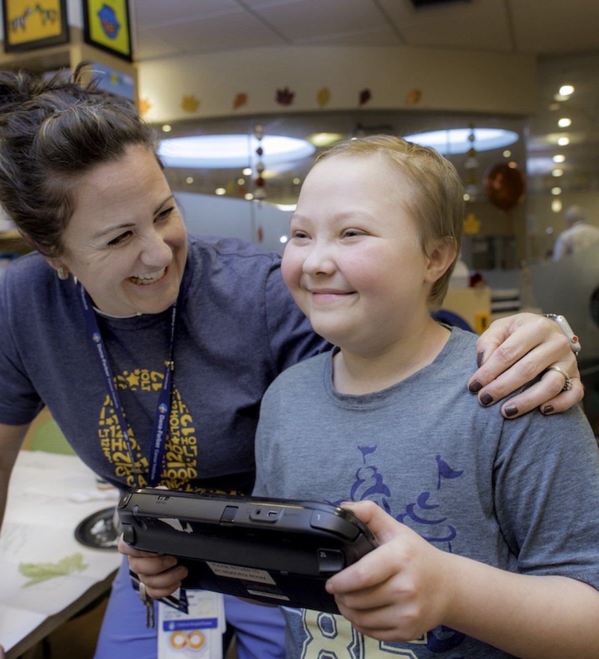 A staff member and patient playing a video game