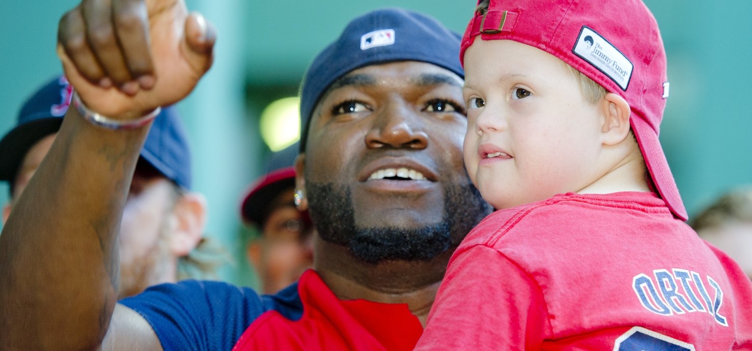 David Ortiz holds a patient in his arms and points into the distance