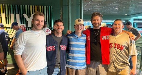 Corey stands with friends at Fenway Park