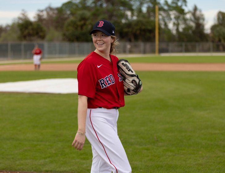 Meghan holds a baseball glove on the field