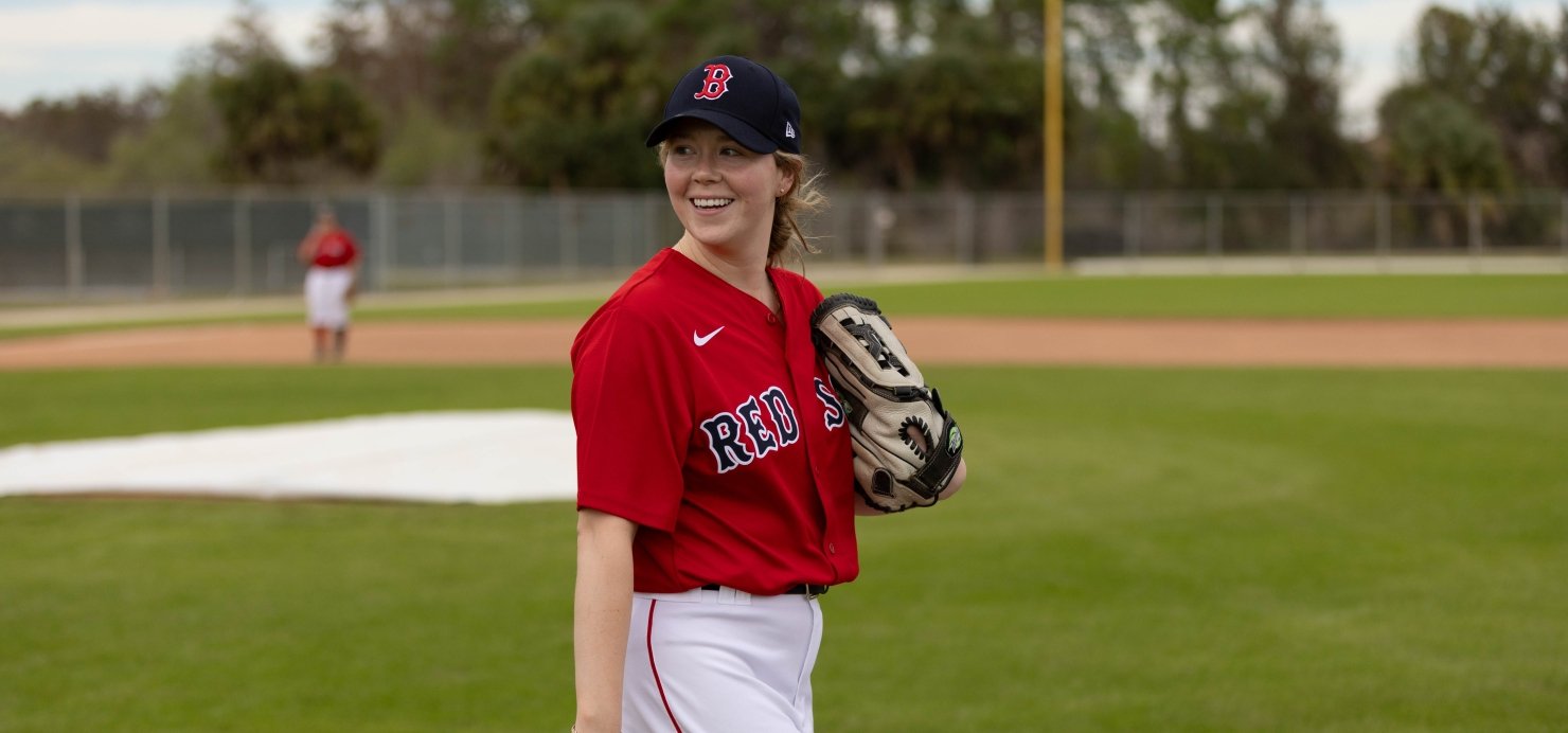 Meghan holds a baseball glove on the field