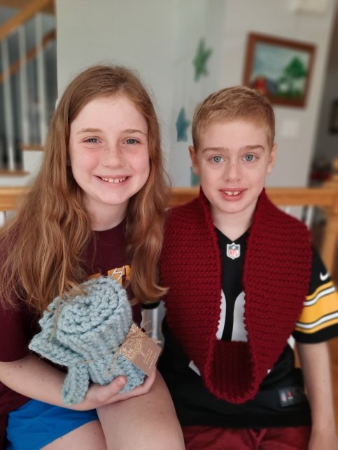 Keene and Heeth sit together holding knitting