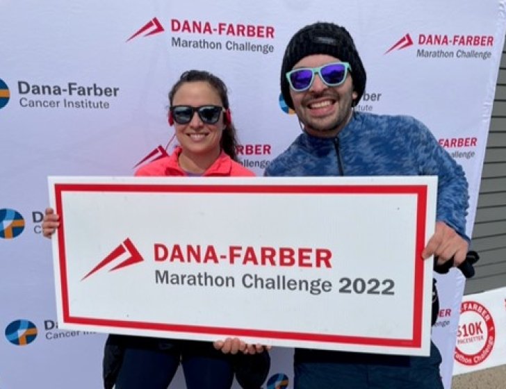 Alfonso and Stephany holding a Dana-Farber Marathon Challenge team sign