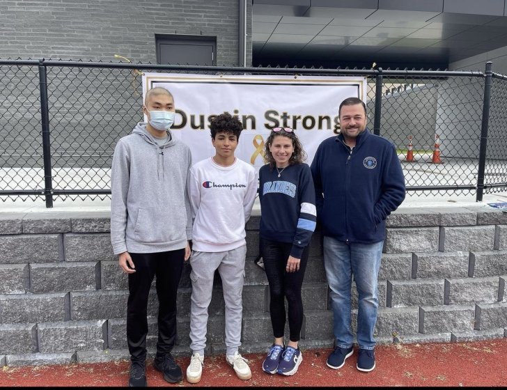 Dustin and Amine stand with two people in front of a Dustin Strong 5K sign