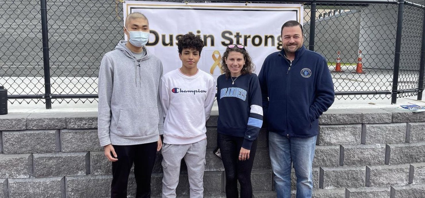 Dustin and Amine stand with two people in front of a Dustin Strong 5K sign