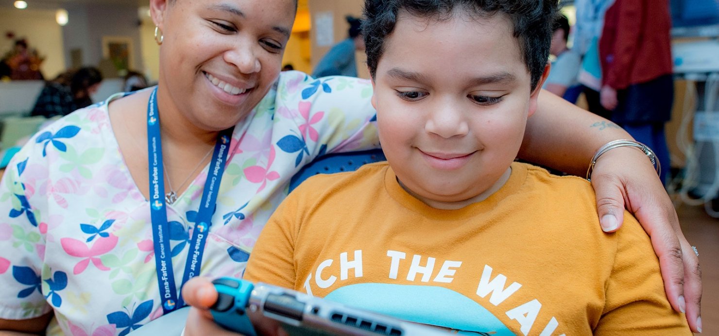 Child and staff member play a video game