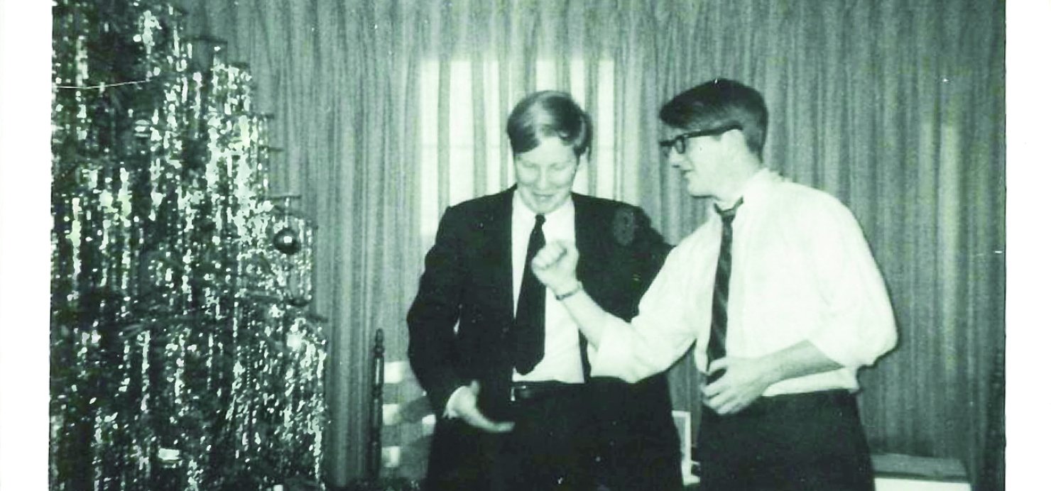 Black and white photo of Richard and Jay in front of a Christmas tree