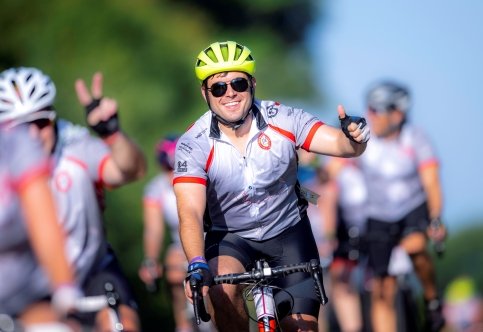 Rider on bike gives thumbs up with other bikers in background