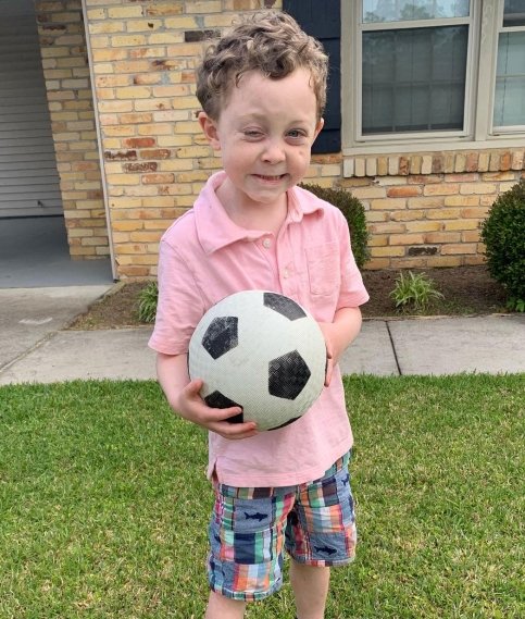 Liam outside holding a soccer ball