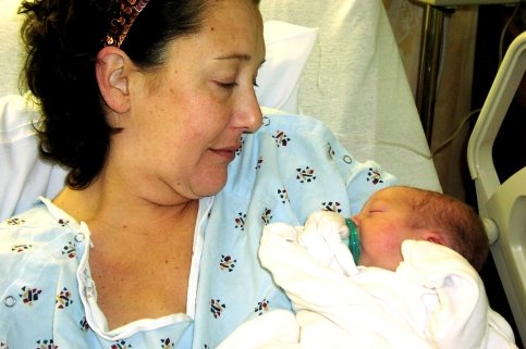 Mother holds newborn in hospital bed