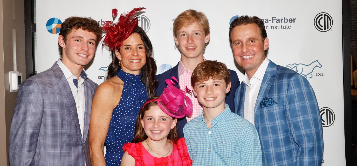 Patient and family stand together wearing suits and dresses
