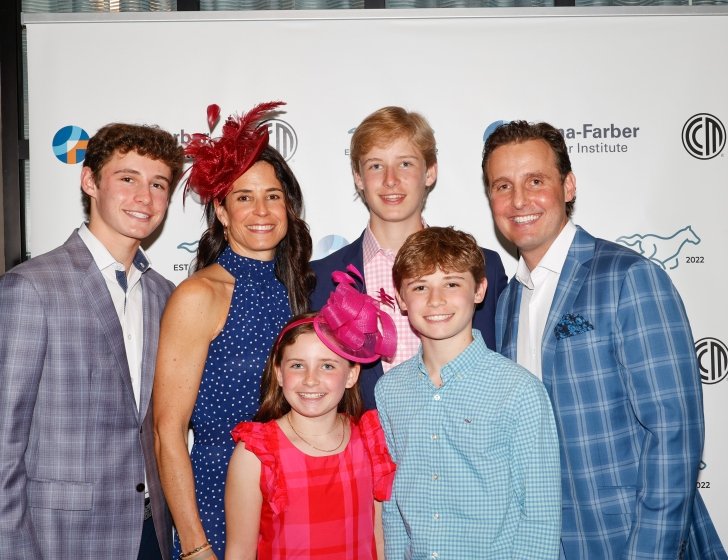 Patient and family stand together wearing suits and dresses