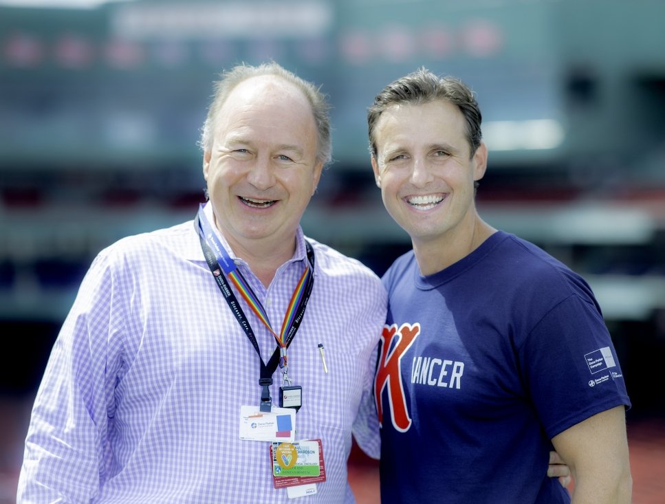 Doctor and patient stand in front of bleachers at Fenway Park