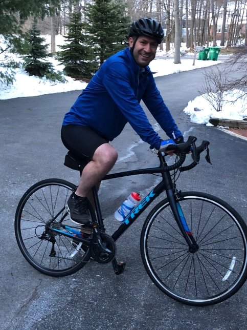 Dr. Choueiri sits on bike surrounded by snowy road