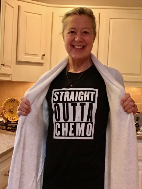 Candace pulls back her sweater revealing a 'Straight Outta Chemo' T-shirt