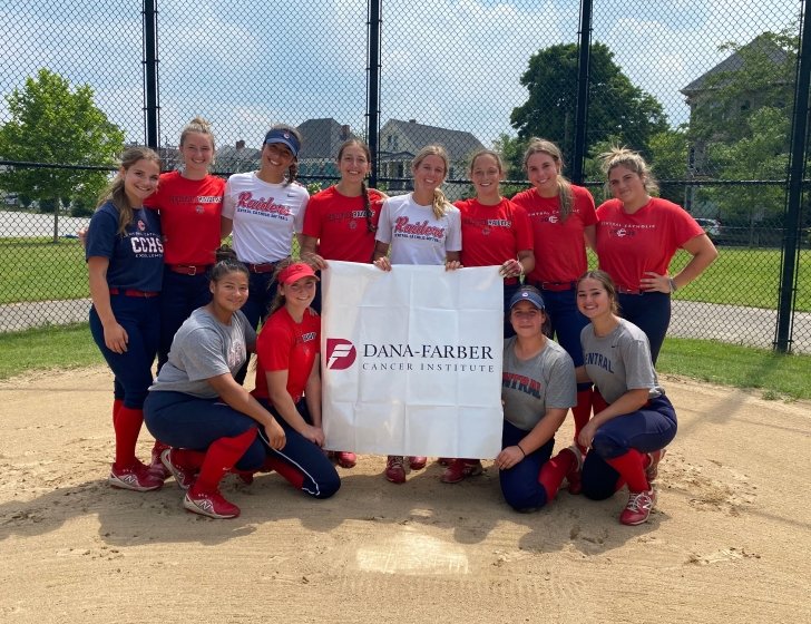 High school softball team on the field holding a Dana-Farber sign