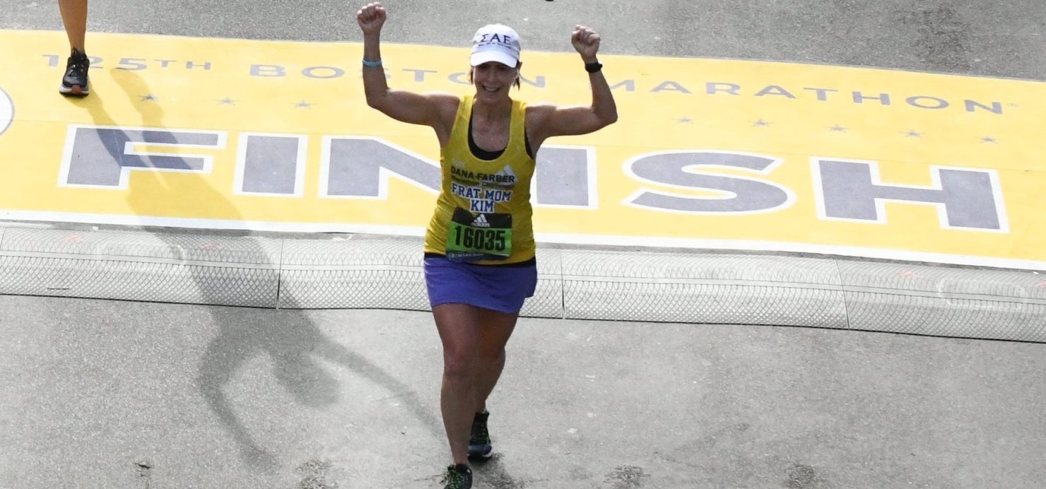 Kim crossing the finish line at a past Boston Marathon