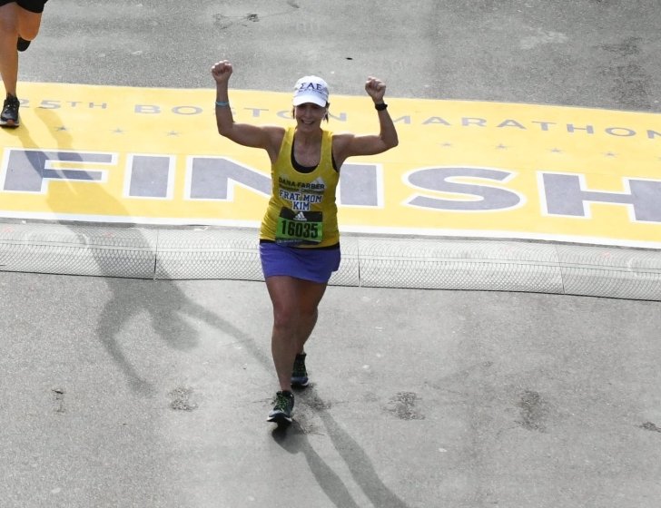 Kim crossing the finish line at a past Boston Marathon