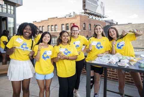 Group of scholars stand together on roof deck wearing Red Sox t-shirts