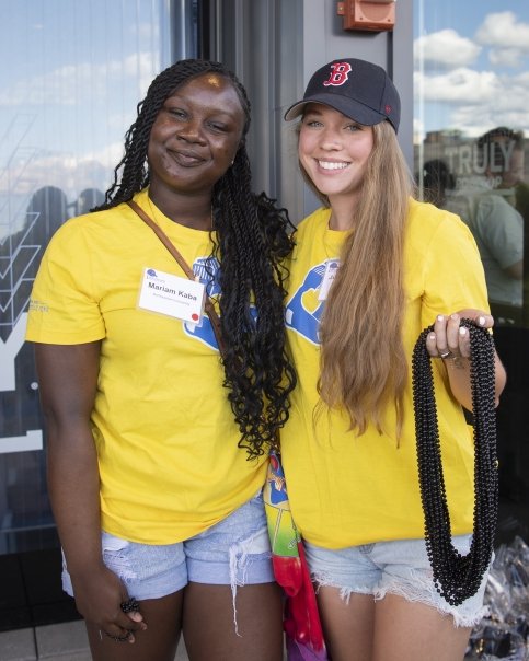 Two people stand together holding bead necklaces