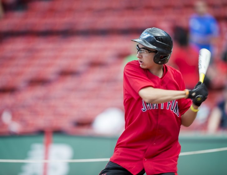 Andrew holds bat, ready to swing at a baseball 