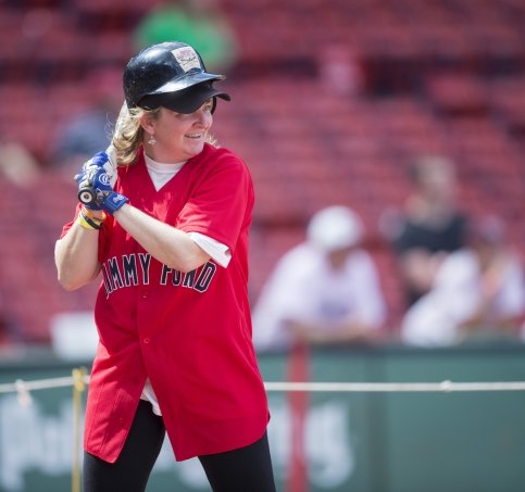 Madaline holds bat, ready to swing at a baseball
