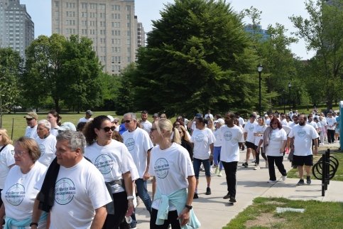 Large group of people walking through a park