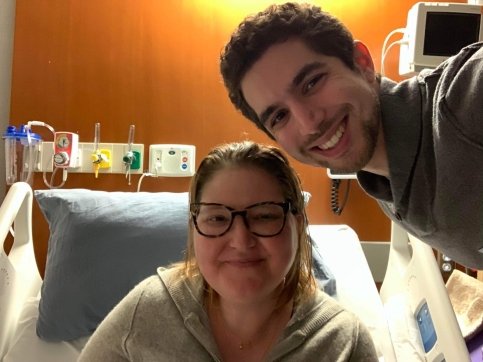 Patient sitting in treatment bed with family member standing next to them