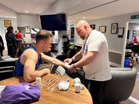 Friend helps Aidan wrap wrist with boxing tape