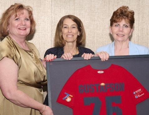 Einar’s daughters with Dana-Farber President and CEO Emerita Laurie H. Glimcher holding a Gustafson jersey