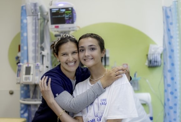Two people hugging in an exam room