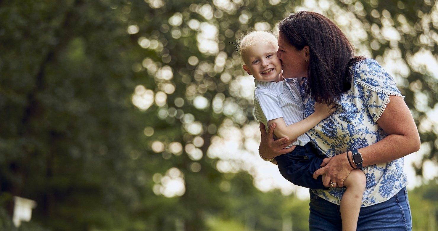 A mother holding her child in a park