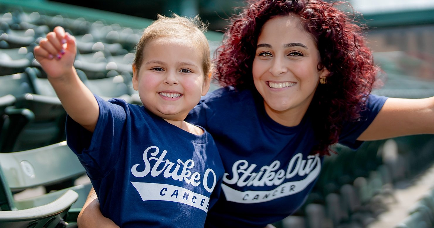 Adult and child wearing Strike Out Cancer T-shirts at Fenway Park
