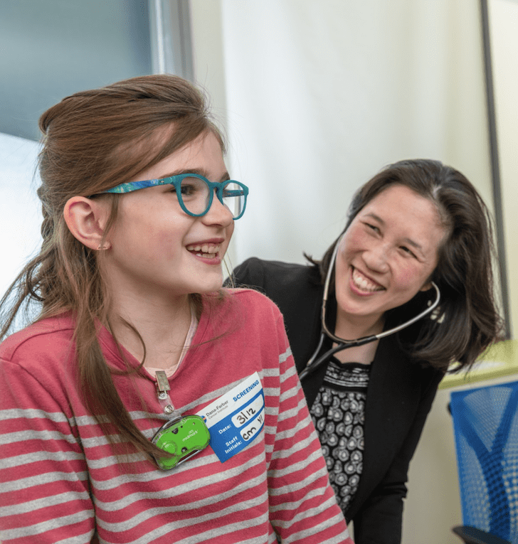 A young patient and her doctor in an exam room