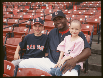 Big Papi and two children sitting in Fenway Park