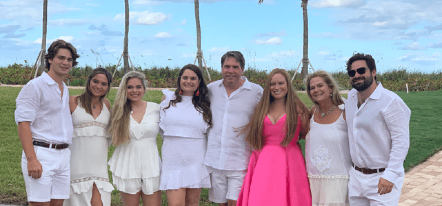 Pace family stands together with palm trees in background