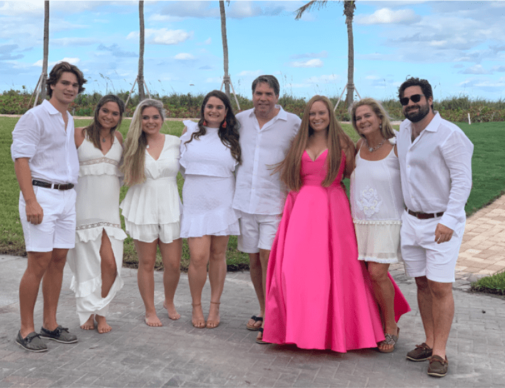 Pace family stands together with palm trees in background