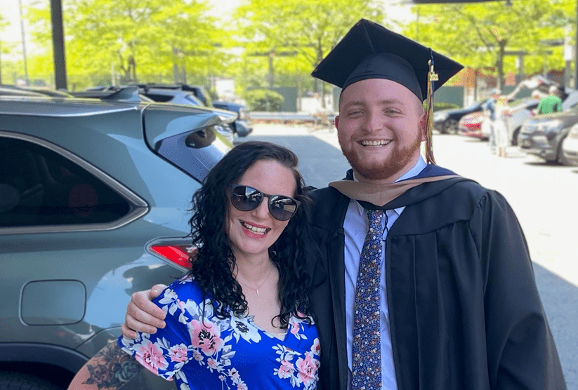 Sean wears graduation gown and hugs his sister